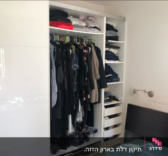 ארון בגדים פתוח עם בגדים תלויים ומקופלים